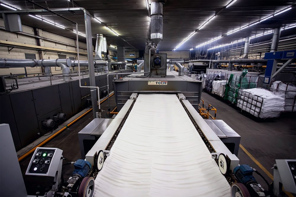 Línea de acabado textil con tela pasando por rodillos