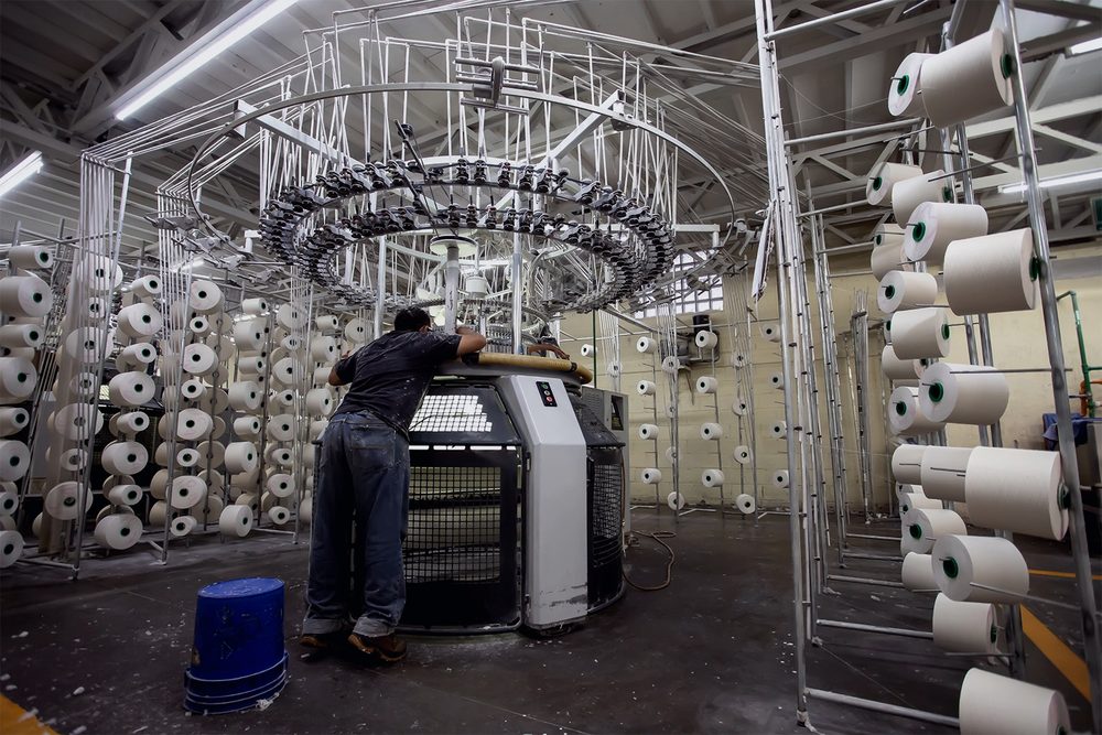 Operario ajustando una máquina de tejido circular en Windsor